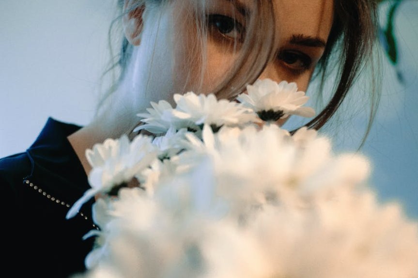 woman in black shirt holding white flowers