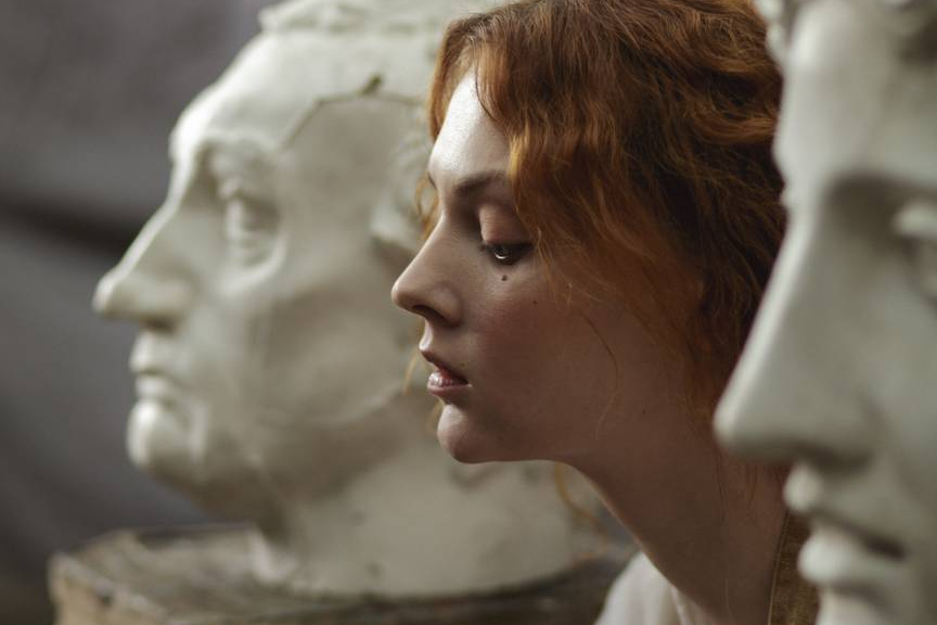 photo of a woman sitting beside statue
